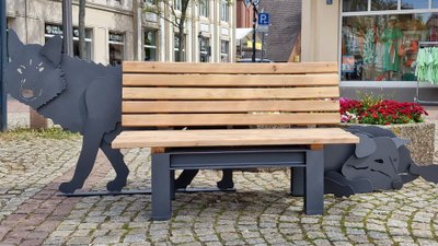 Holzbank mit integriertem Wolfsmotiv als kreative Stadtmöblierung im urbanen Stadtraum der Peiner Innenstadt, die Aufenthaltsqualität stärkt.