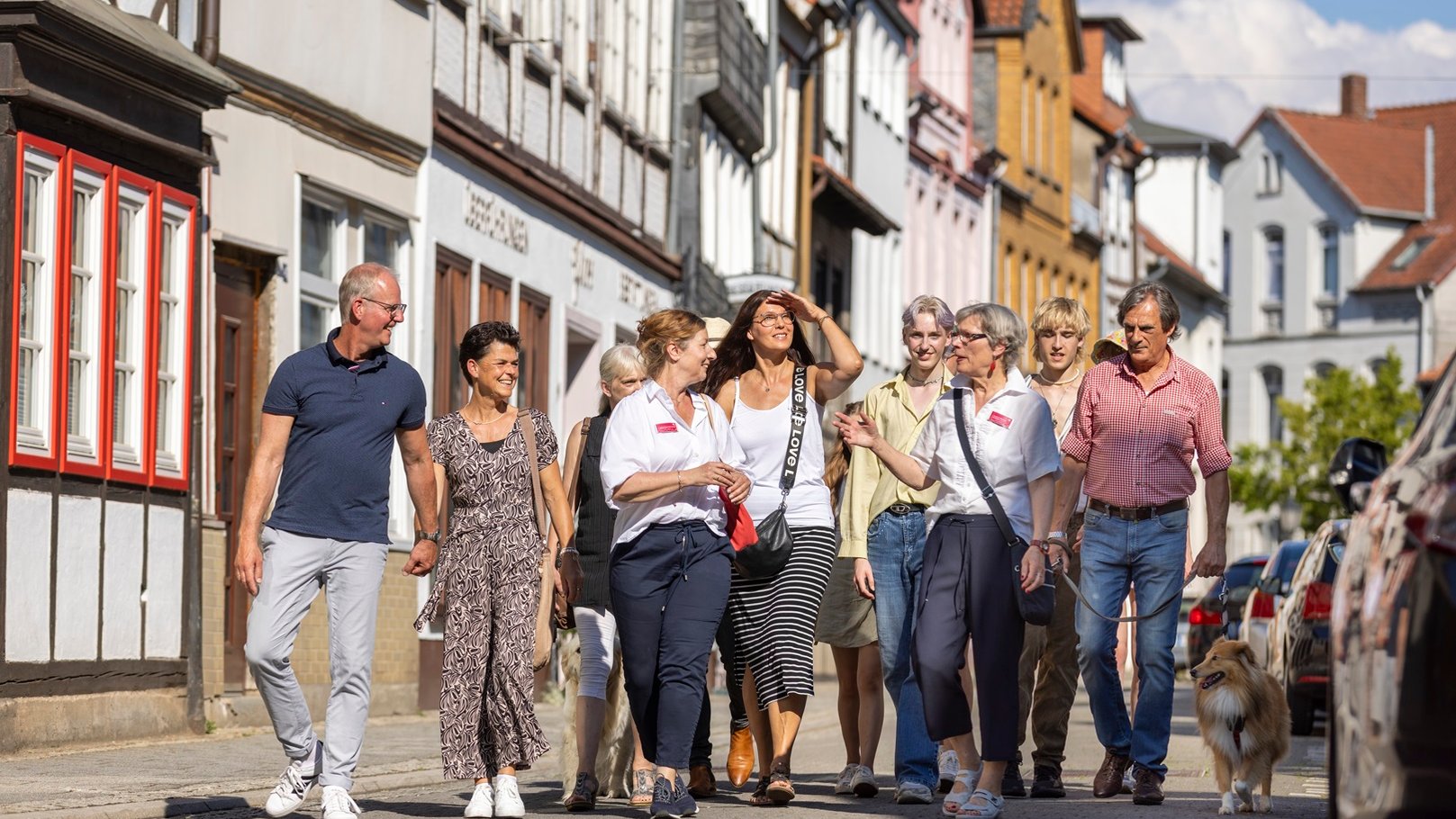 Das Bild zeigt eine Gruppe Menschen, die an einer Stadtführung in Peine teilnehmen und gerade am Damm entlang laufen. 