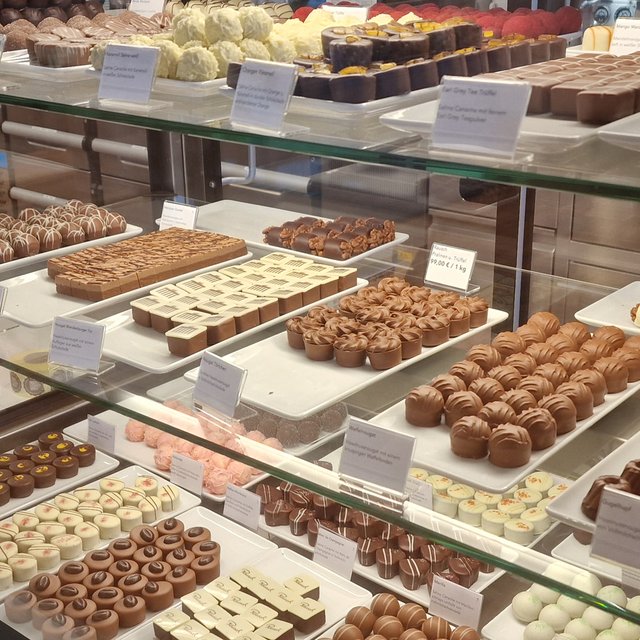 Das Bild zeigt viele verschiedene Pralinen in der Auslage des Cafe im Schokoladenhaus Rausch in Peine. 