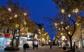 Das Bild zeigt die Weihnachtsbeleuchtung in der Bahnhofstraße in Peine mit vielen Leuchtkugeln in den Bäumen. 