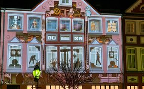 Videomapping-Projektion auf historischer Hausfassade in der Peiner Innenstadt mit animierten Motiven und Lichtkunst bei Nacht.