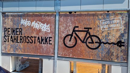 Das Bild zeigt ein Bikeport von hinten, auf dem ein Fahrrad und der Schriftzu Stahlrosstanke zu lesen ist. 