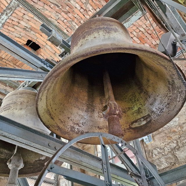 Zwei Glocken der St.-Jakobi-Kirche Peine sind von unten zwischen Stahlträgern und gemauerten Wänden zu sehen.