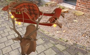 Eine Augmented-Reality-Darstellung eines Rentiers mit Geweih, das vor einem dekorativen, rot gepolsterten Schlitten steht. Der Schlitten ist mit geschwungenen Elementen, kleinen Glocken und leuchtenden Lichtern gestaltet. Die digitalen Objekte sind in eine reale Umgebung mit gepflastertem Boden, Kiesfläche, Natursteinen und einer Backsteinfassade eingebettet.