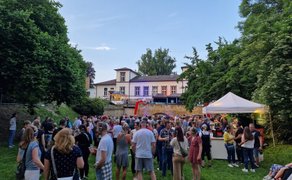 Silent Disco in Peine im Schlosspark: Zahlreiche Besucher tragen Funkkopfhörer, tanzen und feiern gemeinsam bei einer stimmungsvollen Open-Air-Kopfhörerparty vor historischer Kulisse.