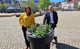 Das Bild zeigt die Geschäftsführerin der Peine Marketing GmbH, Anja Barlen-Herbig, und Peines Bürgermeister Klaus Saemann vor einem neuen Blumenpod in der Peiner Innenstadt. 