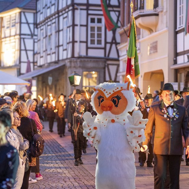 Uhlinchen läuft beim Fackelumzug durch die Peiner Innenstadt, begleitet von Schützen und Zuschauern vor historischer Fachwerkkulisse.