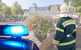 Das Bild zeigt das Blaulicht der Polizei und einen Feuerwehrmann auf dem Historischen Marktplatz in Peine. 