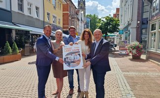 Das Bild zeigt eine Gruppe Menschen, die das neue Stadtmagazin Stadt, Land, Leute in Peine anpreisen. 