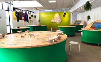 Das Bild zeigt runde Tische, auf denen einen Umweltausstellung im Kreismuseum in Peine zu sehen ist. 