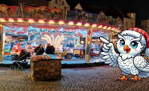 Das Bild zeigt ein Kinderkarussel auf dem Weihnachtsmarkt in Peine. Davor befindet sich ein Comic der Peiner Eule Uhlinchen. 