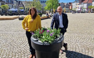 Das Bild zeigt die Geschäftsführerin der Peine Marketing GmbH, Anja Barlen-Herbig, und Peines Bürgermeister Klaus Saemann vor einem neuen Blumenpod in der Peiner Innenstadt. 