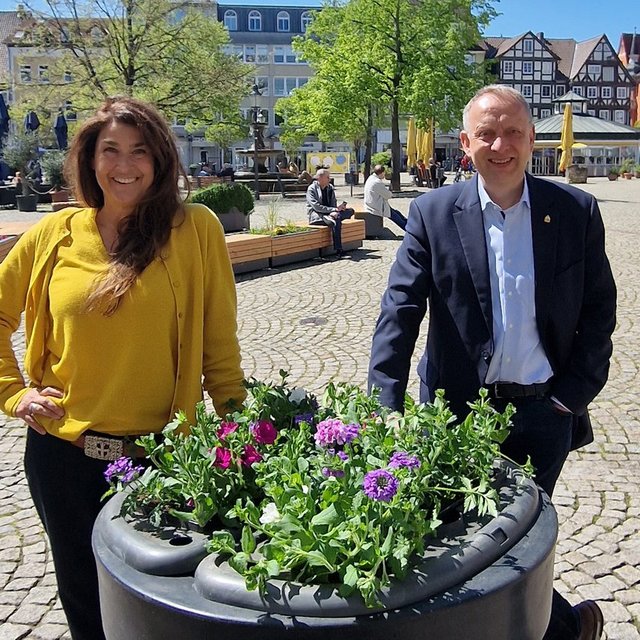 Das Bild zeigt die Geschäftsführerin der Peine Marketing GmbH, Anja Barlen-Herbig, und Peines Bürgermeister Klaus Saemann vor einem neuen Blumenpod in der Peiner Innenstadt. 