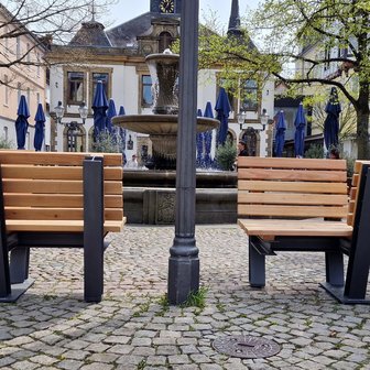 Das Bild zeigt Bänke, auf denen man sich gegenüber sitzt, auf dem Historischen Marktplatz in Peine, was als Kunst im öffentlichen Raum gilt. 