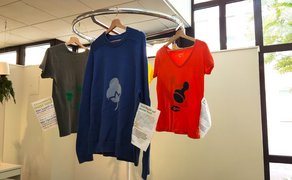 Das Bild zeigt Tshirts, die an der Decke aufgehängt sind. 