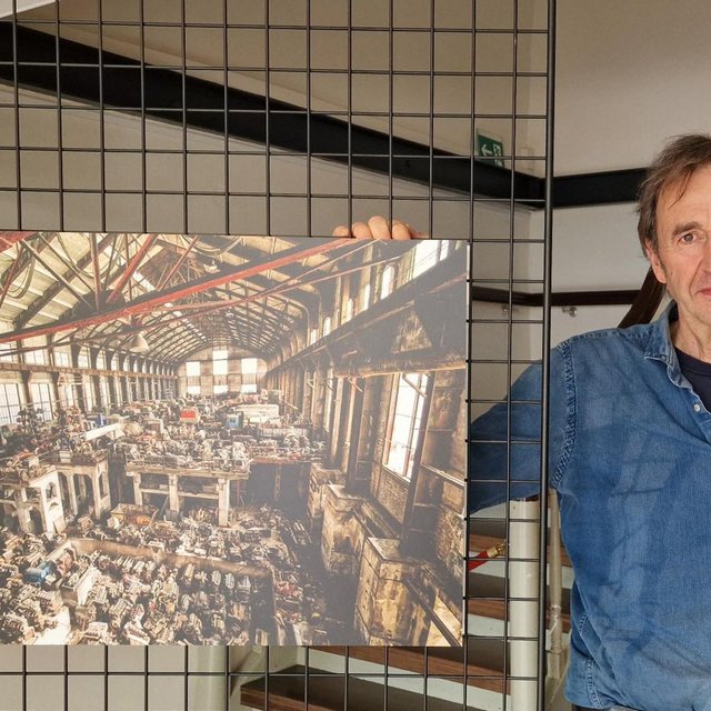 Das Bild zeigt einen Künstler neben seinem Kunstwerk im Schwan in Peine.