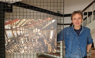 Das Bild zeigt einen Künstler neben seinem Kunstwerk im Schwan in Peine.