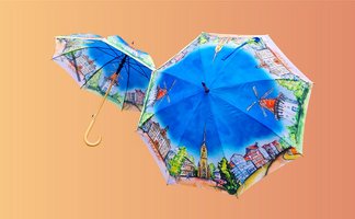 Das Bild zeigt zwei bunte Regenschirme mit gemalten Motiven aus Peine drauf. 