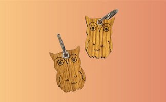 Das Bild zeigt zwei Schlüsselanhänger aus Holz in Form einer Eule. 