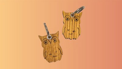 Das Bild zeigt zwei Schlüsselanhänger aus Holz in Form einer Eule. 