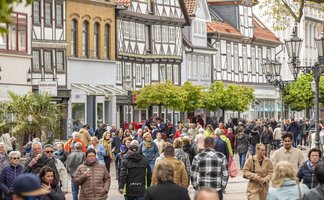 Das Bild zeigt Passanten beim Einkaufen in der Fußgängerzone in Peine.