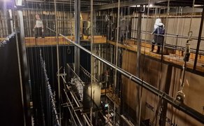 Das Bild zeigt Besucher im Schnürboden des Stadttheaters sowie mehrere Seilzüge.