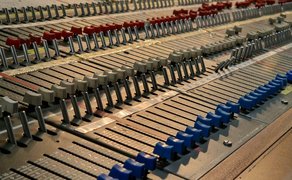 Das Bild zeigt zahlreiche Schieberegler eines alten Lichtmischpults.