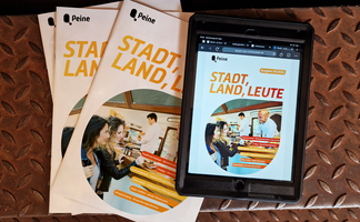 DAs Bild zeigt ein Tablet mit dem Stadtmagazin Stadt, Land, Leute darauf. Daneben liegen einige gedruckte Exemplare. 