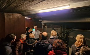 Das Bild zeigt eine Besuchergruppe im Orchestergraben des Stadttheaters. 