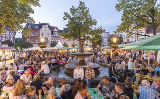 Das Bild zeigt viele Menschen auf dem Historischen Marktplatz in Peine, die es sich beim Weinfest gutgehen lassen. 