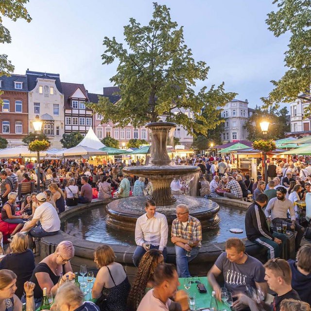 Das Bild zeigt viele Menschen auf dem Historischen Marktplatz in Peine, die es sich beim Weinfest gutgehen lassen. 