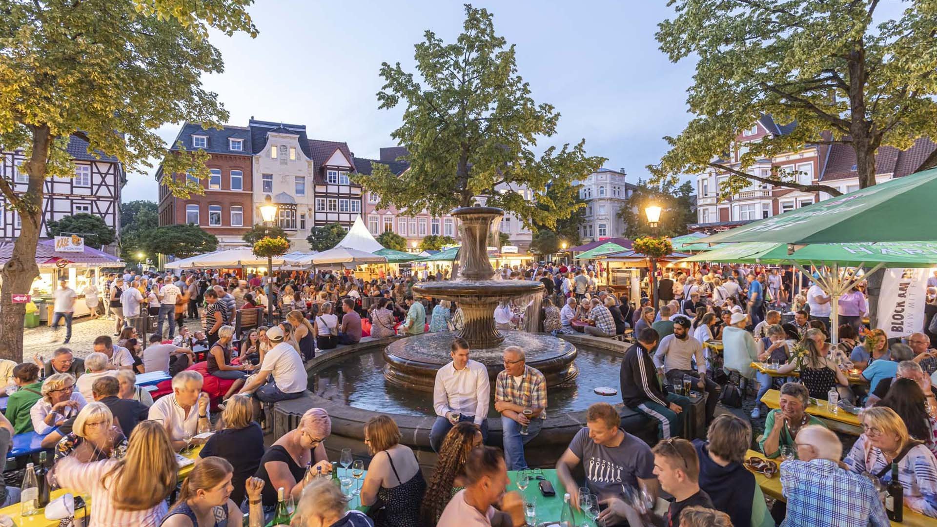 Das Bild zeigt viele Menschen auf dem Historischen Marktplatz in Peine, die es sich beim Weinfest gutgehen lassen. 